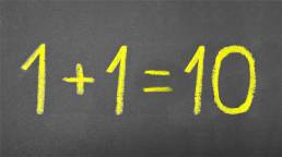 Basic arithmetic equation written on a chalkboard - 1 + 1 = 10