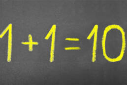 Basic arithmetic equation written on a chalkboard - 1 + 1 = 10